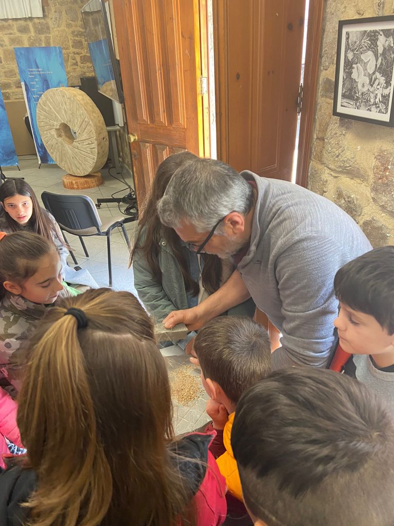 Ángel Lorenzo, miembro del equipo del proyecto, explicando a escolares la técnica básica de la molienda